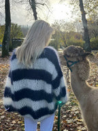 Women's navy and white chunky striped sweater made of soft knit fabric, featuring a relaxed fit and ribbed cuffs.
