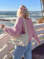 Women's off-shoulder knitted sweater in soft fabric, featuring stylish ties for a chic, relaxed look. Perfect for layering.
