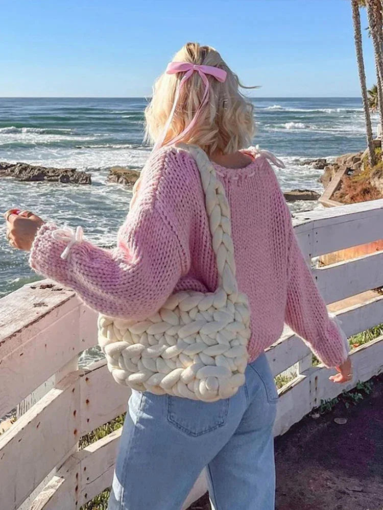 Women's off-shoulder knitted sweater in soft fabric, featuring stylish ties for a chic, relaxed look. Perfect for layering.