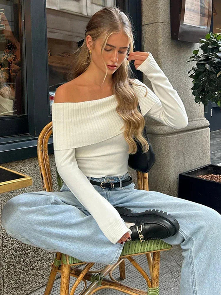 Women's off-shoulder white sweater featuring a ribbed neckline and soft knit material for comfort and casual style.