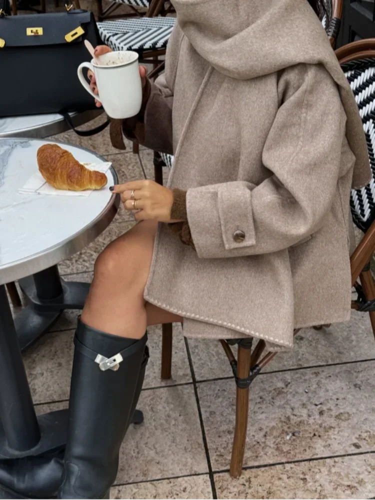 Women's oversized beige coat featuring large buttons, made from soft twill fabric, perfect for layering in cooler weather.