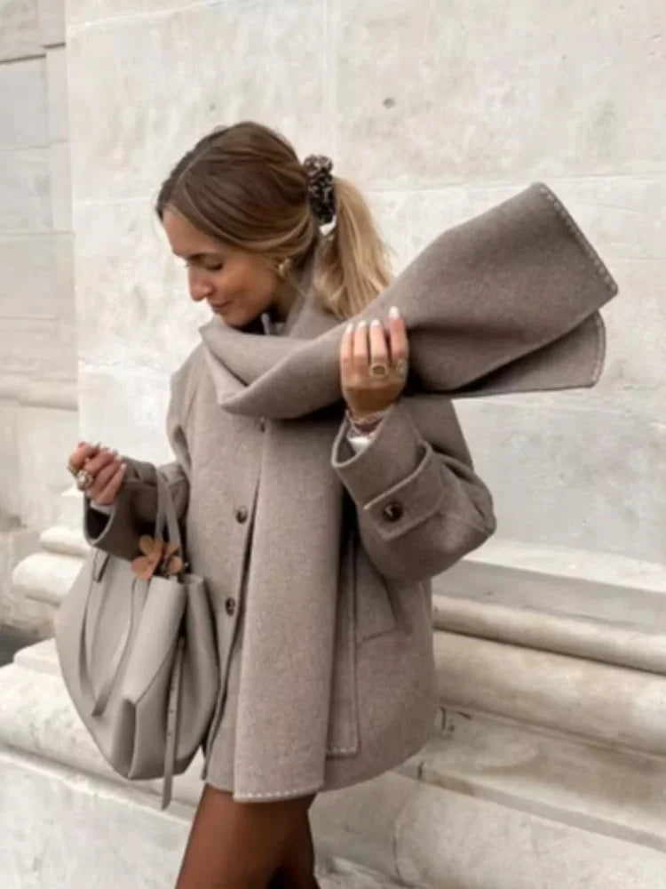 Women's oversized beige coat made from soft wool blend, featuring large buttons and a relaxed fit for comfort and style.