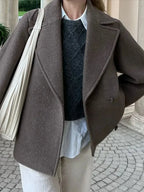 Women's oversized brown jacket featuring button closure, made of soft fabric with a relaxed fit and spacious pockets.
