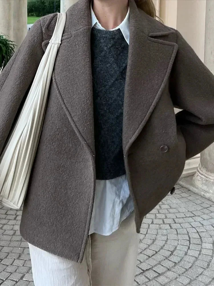 Women's oversized brown jacket featuring button closure, made of soft fabric with a relaxed fit and spacious pockets.