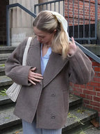 Women's oversized brown jacket featuring button closure, crafted from soft fabric with a relaxed fit for comfort and style.
