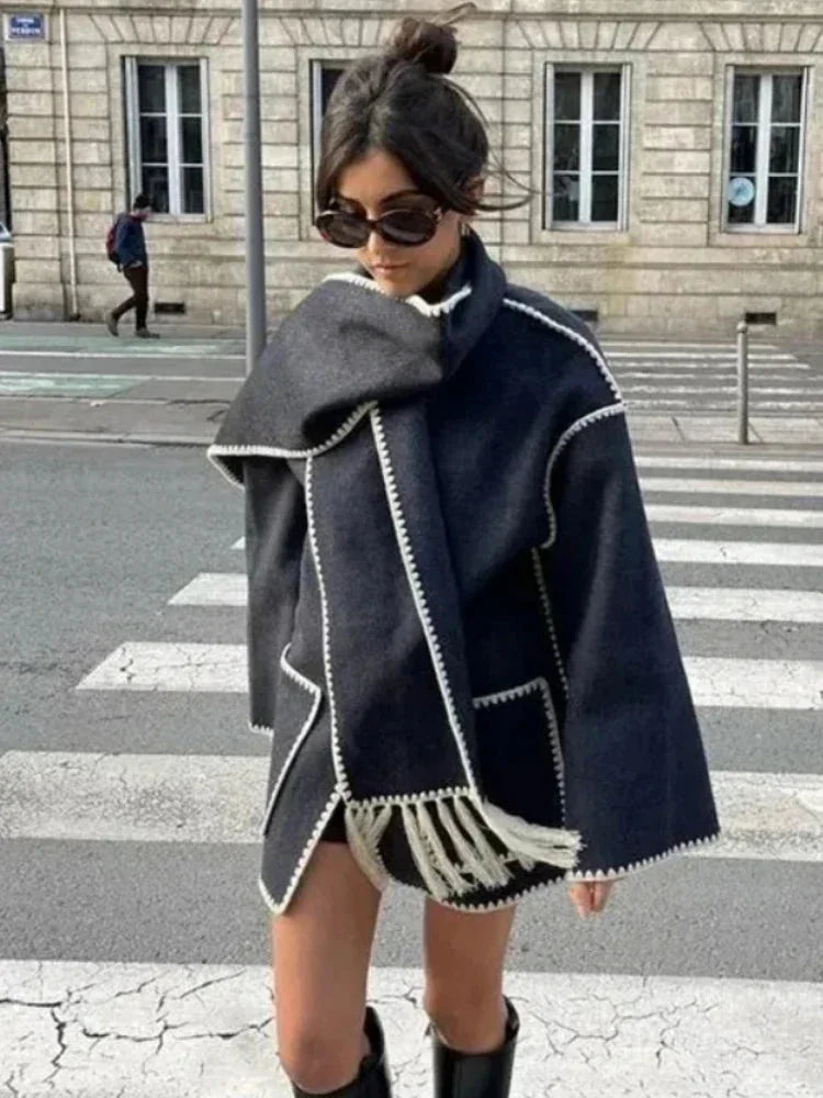 Women's oversized coat made from soft fabric, featuring an integrated scarf and stylish fringe details for added warmth.