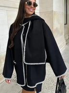 Women's oversized coat made of soft fabric, featuring an integrated scarf and stylish fringe detail for added warmth and…