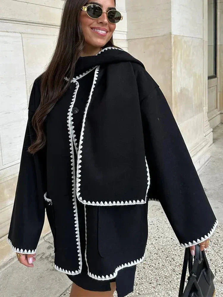 Women's oversized coat made of soft fabric, featuring an integrated scarf and stylish fringe detail for added warmth and…