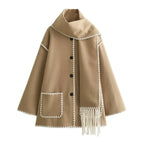 Women's oversized coat with integrated scarf and fringe, made from soft wool blend, featuring a relaxed fit and unique…
