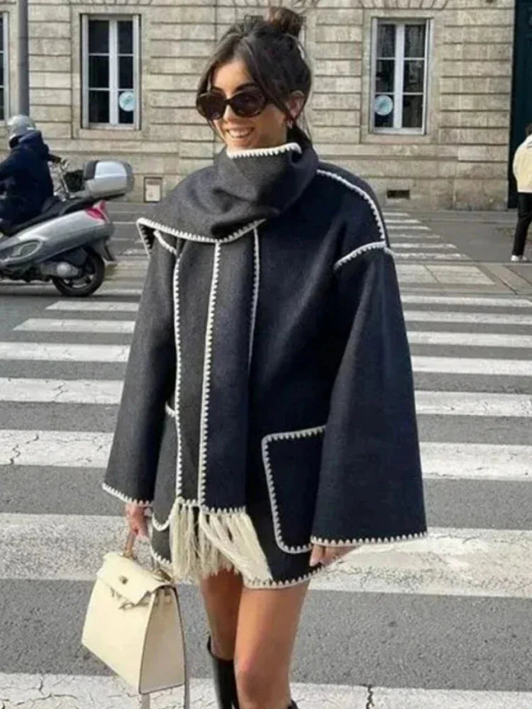 Women's oversized coat in soft wool blend, featuring an integrated scarf and fringe details for added warmth and style.