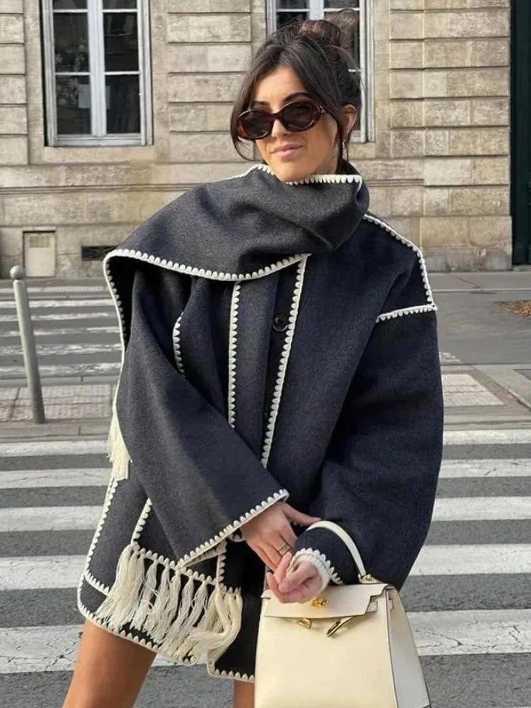 Women's oversized coat in soft wool blend, featuring an integrated scarf and fringe detailing for added texture and warmth.