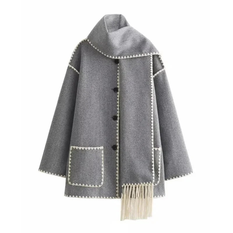 Women's oversized coat made of soft fabric, featuring an integrated scarf and stylish fringe detailing for added warmth.