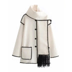 Women's oversized coat in soft wool blend featuring an integrated scarf and playful fringe detail for added warmth.