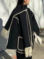 Women's oversized coat in soft fabric, featuring an integrated scarf and stylish fringe detail for added flair and warmth.