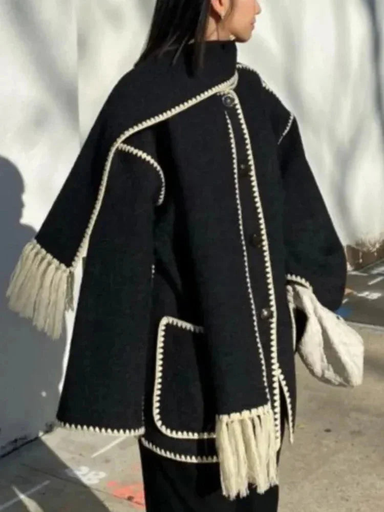 Women's oversized coat in soft fabric, featuring an integrated scarf and stylish fringe detail for added flair and warmth.