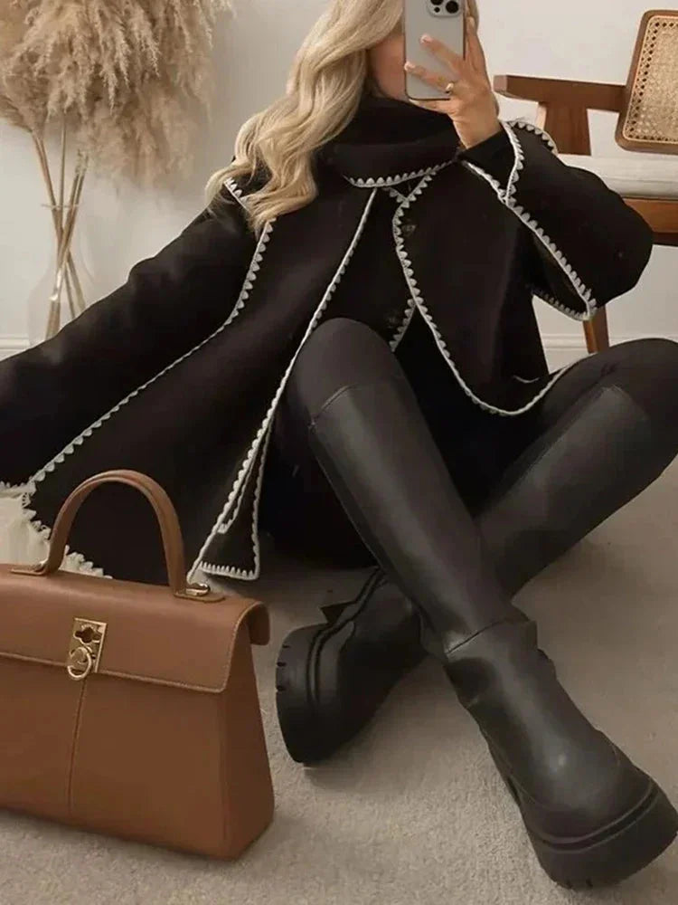 Women's oversized coat in soft fabric featuring an integrated scarf and fringe detailing for added texture and warmth.