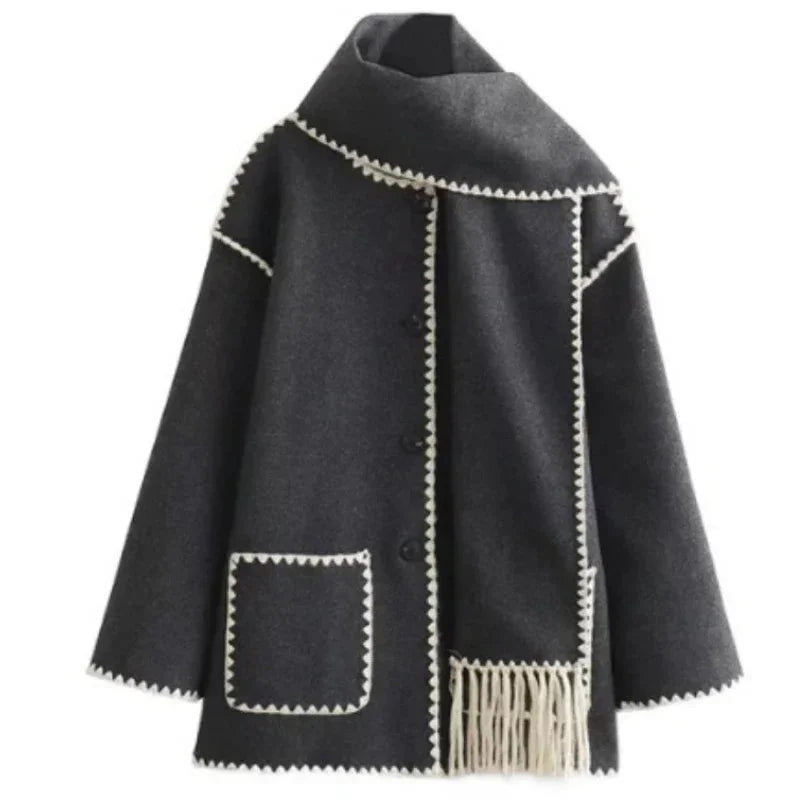 Women's oversized coat in soft fabric featuring an integrated scarf and fringe detailing for added texture and warmth.