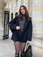 Women's oversized coat with wide lapels and button closure, made from soft wool blend for warmth and style.