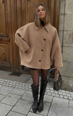 Women's oversized coat featuring wide lapels, button closure, and a soft wool blend for warmth and comfort in cool weather.