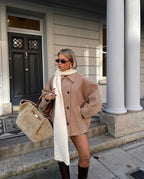Women's oversized coat with wide lapels, button closure, crafted from soft wool blend for warmth and comfort.