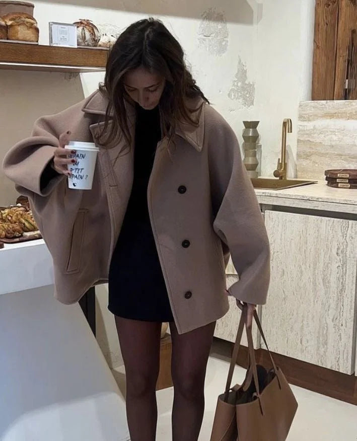 Women's oversized coat featuring wide lapels, button closure, and a cozy fabric, perfect for layering in cool weather.