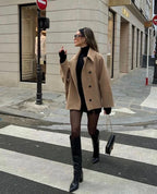Women's oversized coat featuring wide lapels, button closure, and made from warm, durable fabric for comfort and versatility.