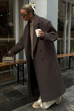 Women's oversized gray coat featuring a double-breasted design and soft fabric for warmth and comfort. Ideal for layering.