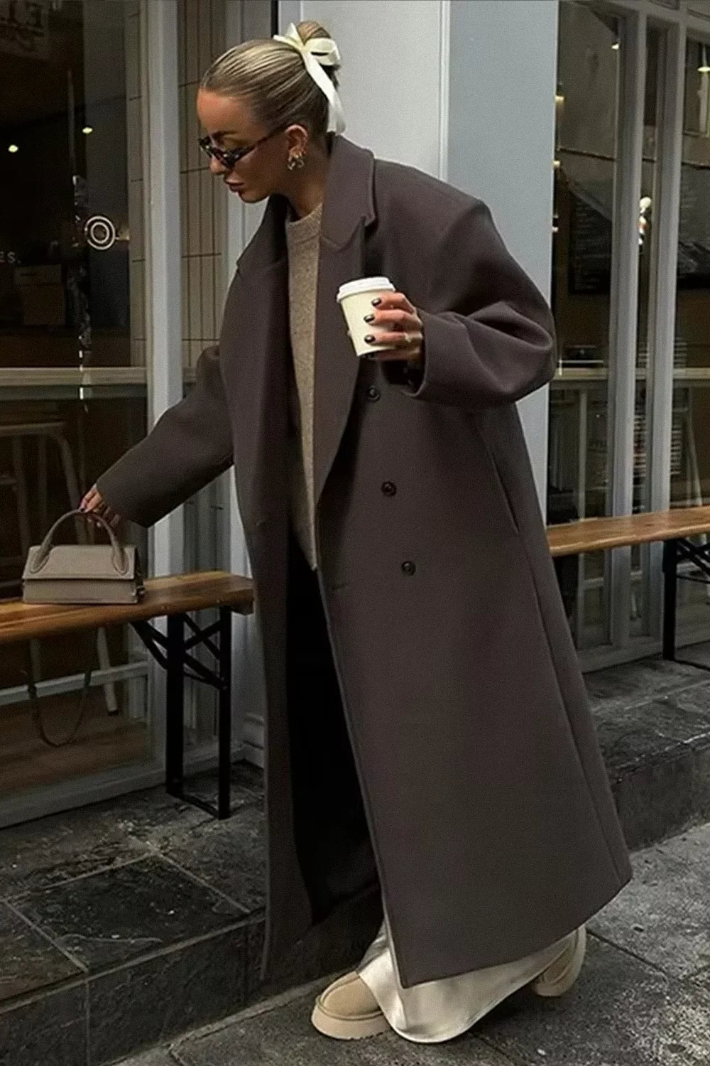 Women's oversized gray coat featuring a double-breasted design and soft fabric for warmth and comfort. Ideal for layering.