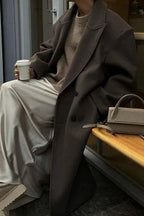 Women's oversized gray coat featuring a double-breasted design and made from soft, warm fabric perfect for colder weather.