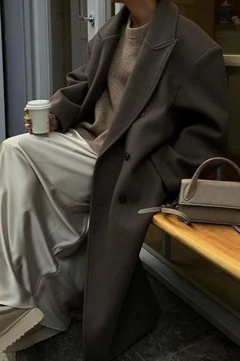 Women's oversized gray coat featuring a double-breasted design and made from soft, warm fabric perfect for colder weather.