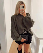 Women's oversized knit sweater featuring cozy balloon sleeves, crafted from soft acrylic yarn for warmth and comfort.