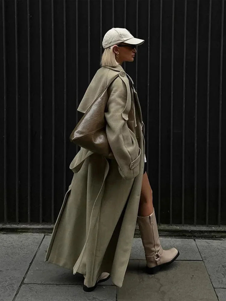 Women’s oversized long trench coat with wide lapels, made of soft cotton blend, featuring a belted waist and spacious…