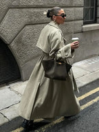 Women's oversized long trench coat with wide lapels, crafted from lightweight fabric, perfect for layering in cooler weather.