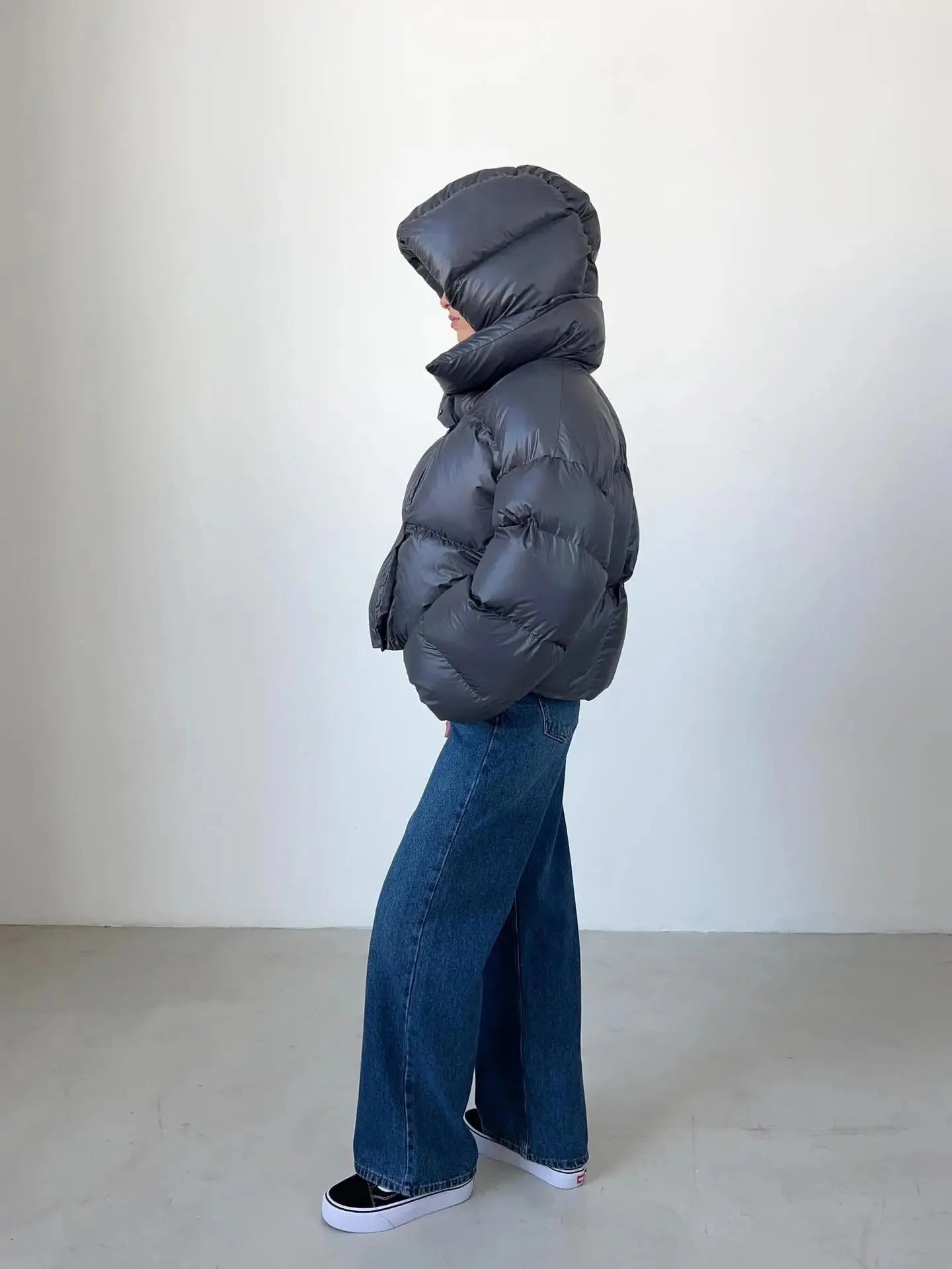 Women's oversized puffer coat featuring a high collar, crafted from warm, water-resistant fabric with spacious pockets.