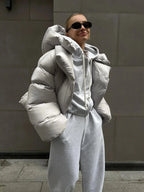Women's oversized puffer coat in durable nylon, featuring a high collar and spacious design for comfort and warmth.