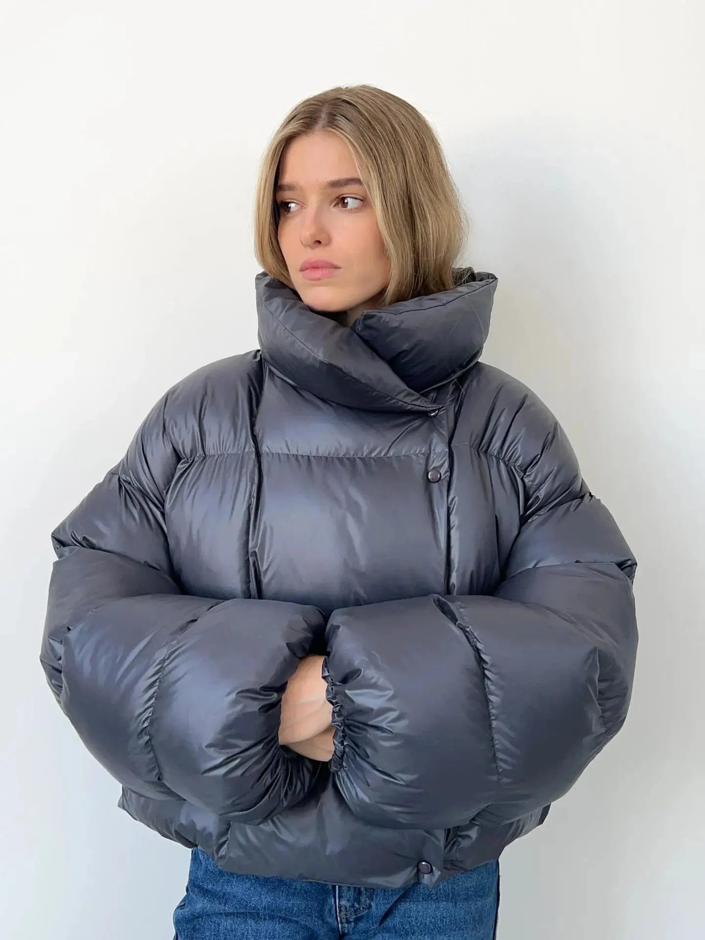 Women's oversized puffer coat with a high collar, featuring a quilted design and soft, insulated fabric for warmth.