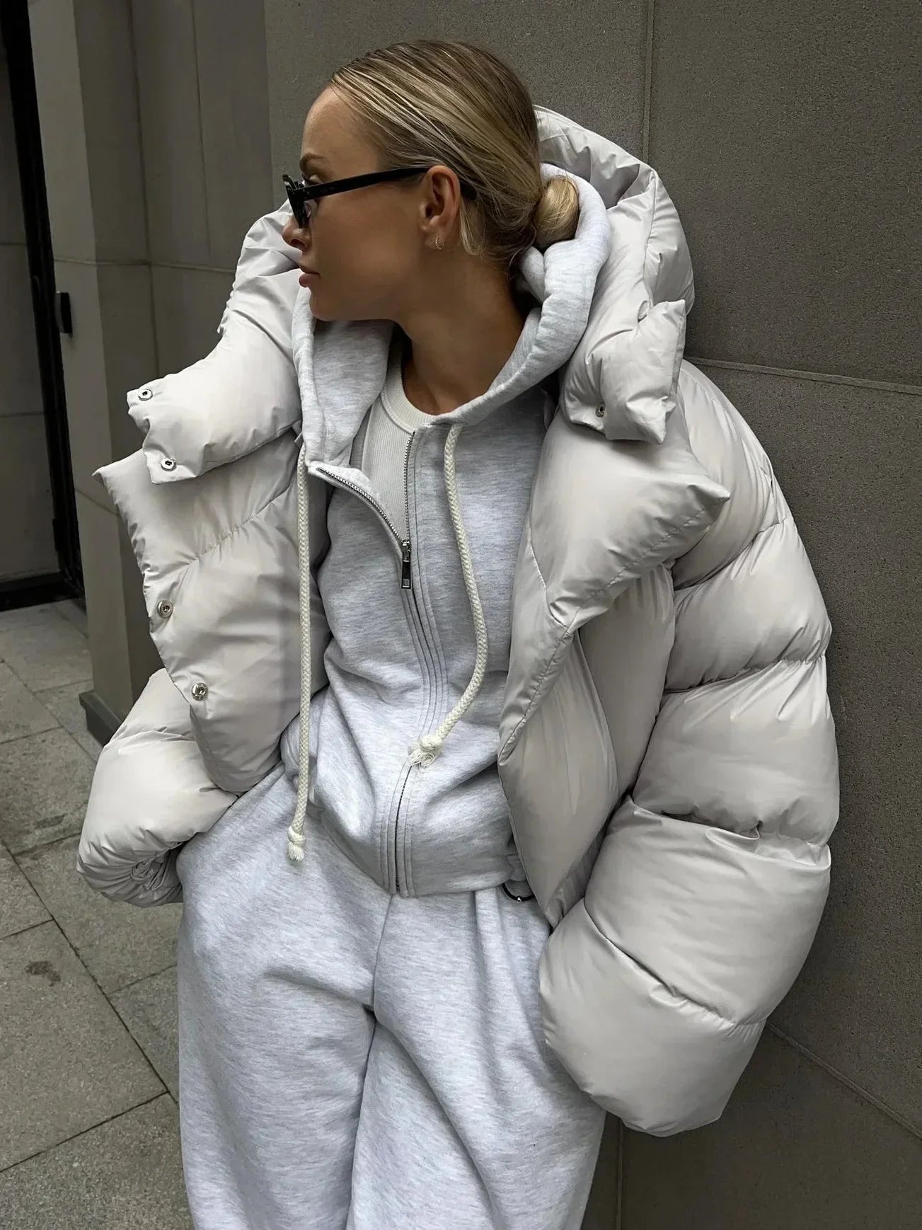 Women's oversized puffer coat with high collar, crafted from quilted fabric for warmth and comfort in cold weather.