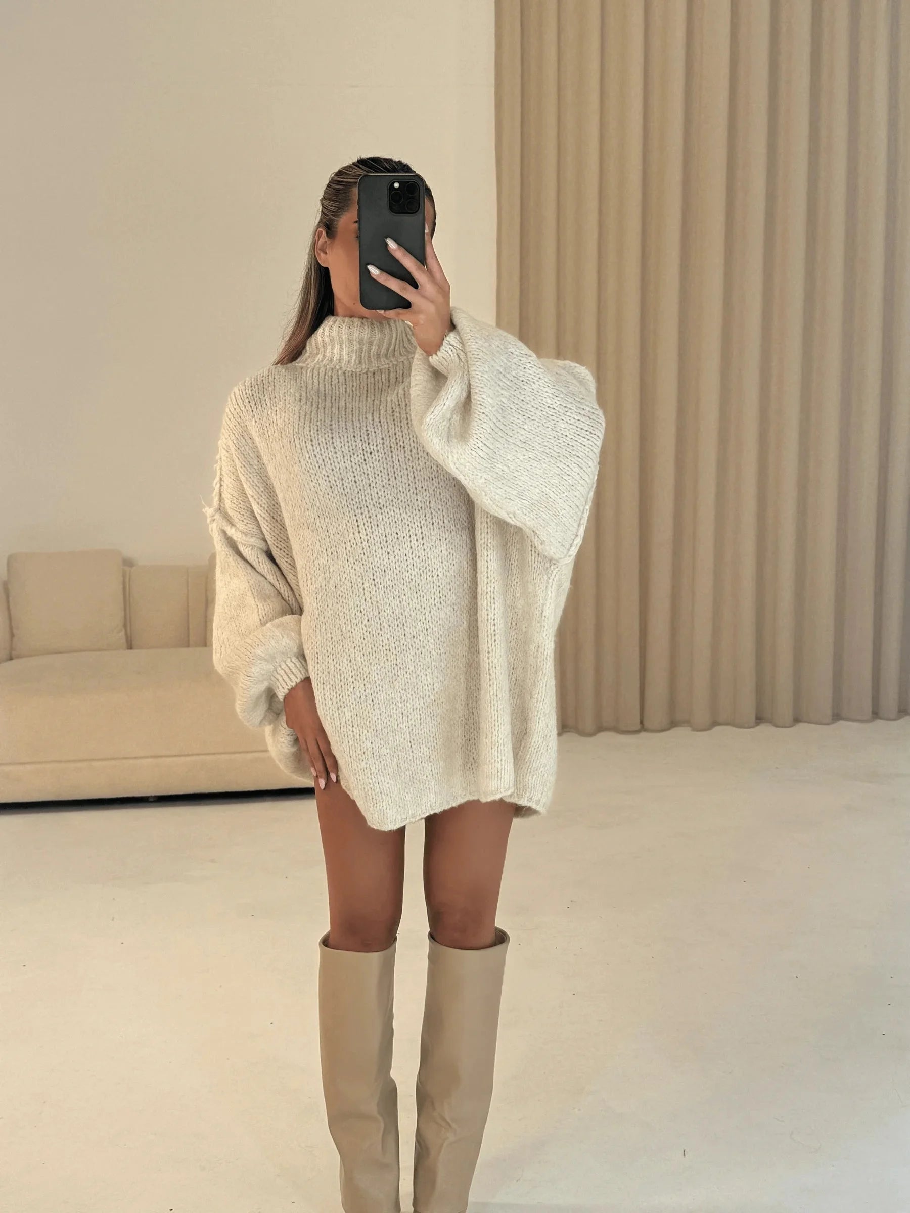 Women's oversized pullover sweater in soft knit fabric with a cozy high neckline and relaxed fit for comfortable layering.
