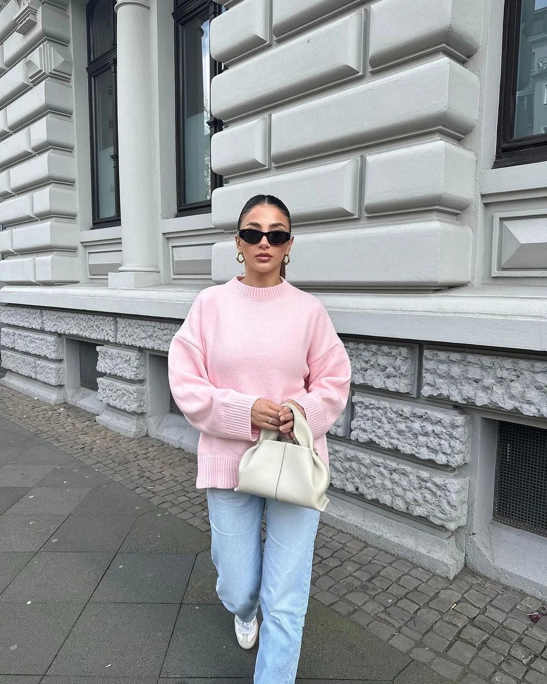 Soft pink oversized sweater for women, featuring long sleeves and a cozy knit material for added comfort and style.