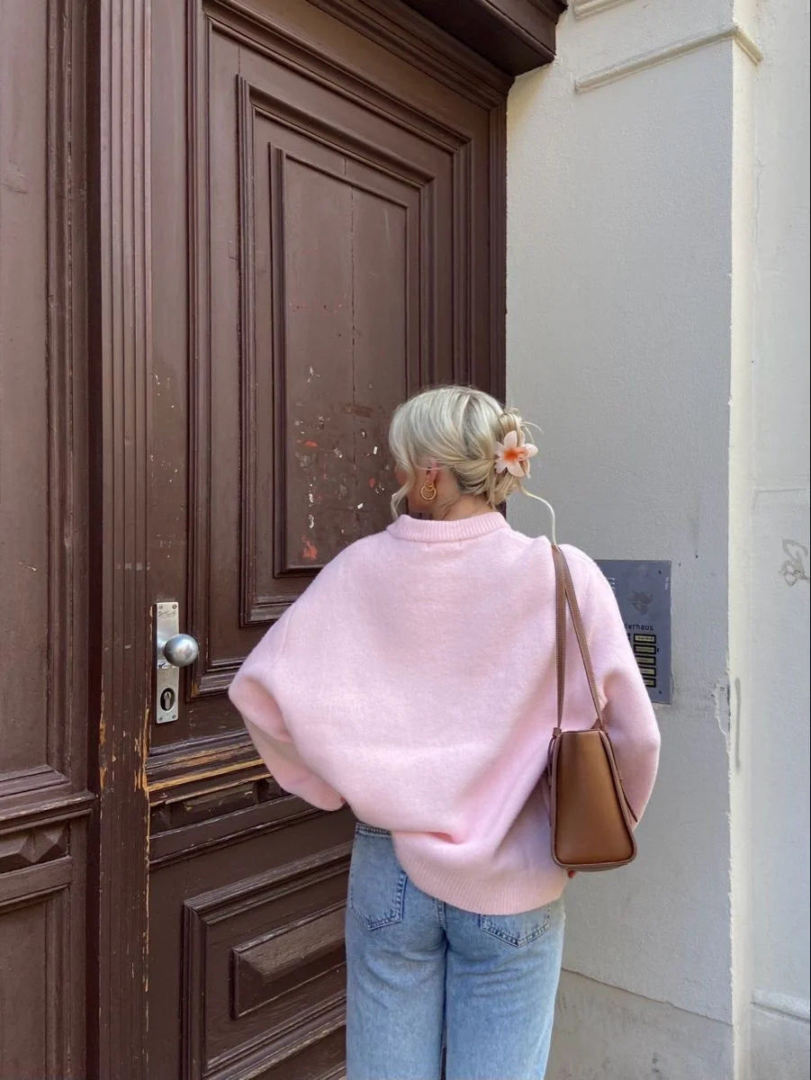 Women's oversized soft pink sweater made of cozy knit fabric, featuring long sleeves and a relaxed fit for comfort.
