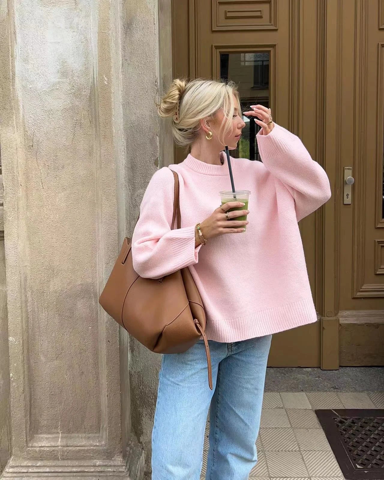 Women's oversized soft pink sweater with long sleeves, made from cozy knit material, featuring a relaxed fit and ribbed…