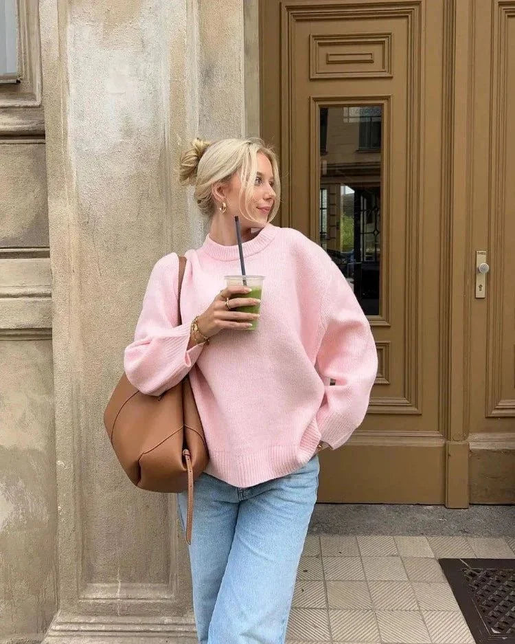 Women's oversized soft pink sweater made of cozy knit fabric, featuring long sleeves and a relaxed fit for comfort.