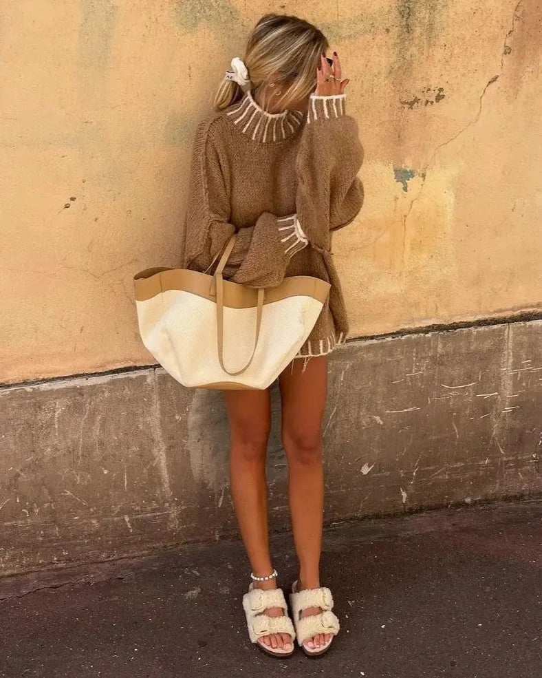 Women's oversized sweater in soft knit, featuring striped details and a relaxed fit for comfortable everyday wear.