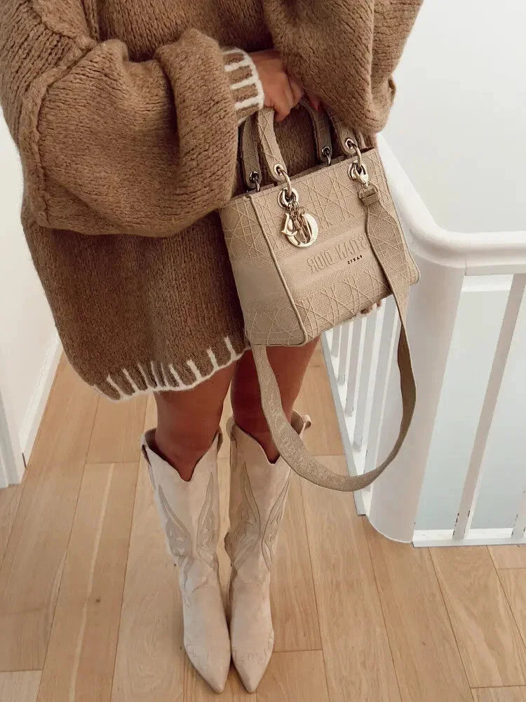 Woman's oversized sweater in soft knit, featuring horizontal stripes and a relaxed fit for comfort and style.