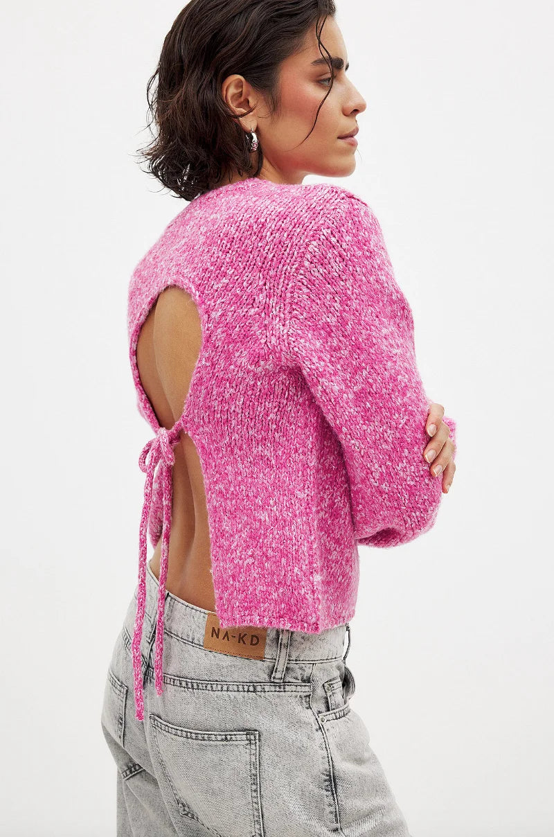 Women's backless pink pullover with long sleeves, made of soft cotton blend, featuring a stylish open back design.