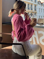 Women's pink backless pullover featuring long sleeves, made from soft knit fabric for comfortable everyday wear.