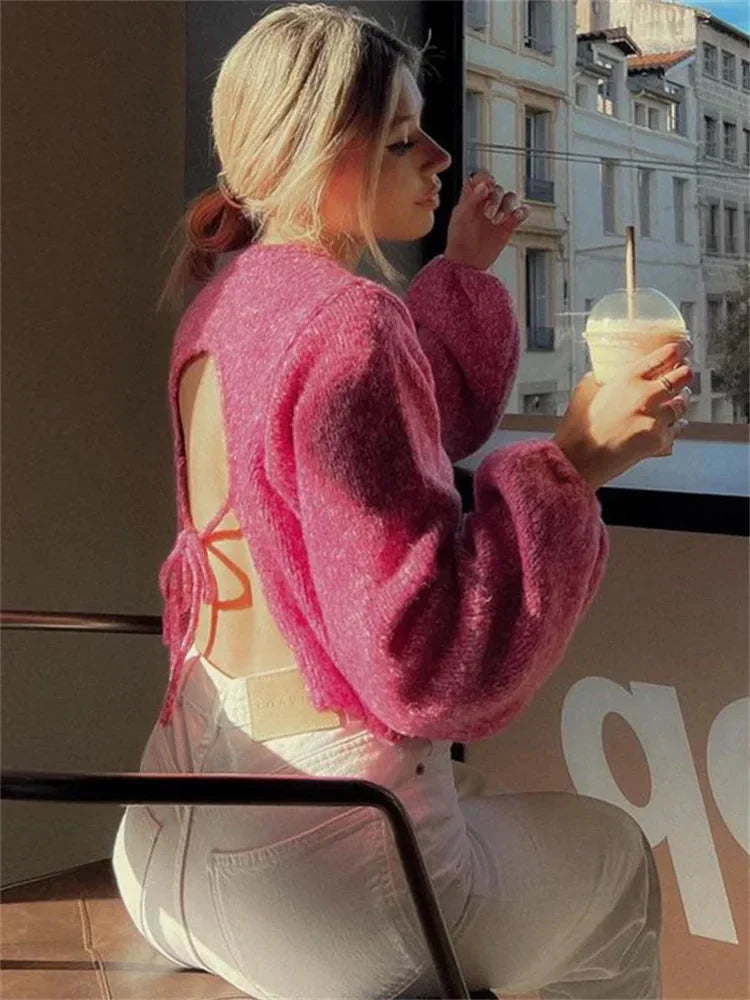Women's pink backless pullover made of soft cotton, featuring long sleeves and a stylish open-back design for a casual look.