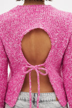 Women's pink backless pullover with long sleeves, made of soft knit fabric, featuring a stylish open back design.