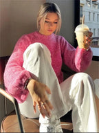 Women’s pink backless pullover with long sleeves, made from soft cotton blend, featuring a unique open-back design.