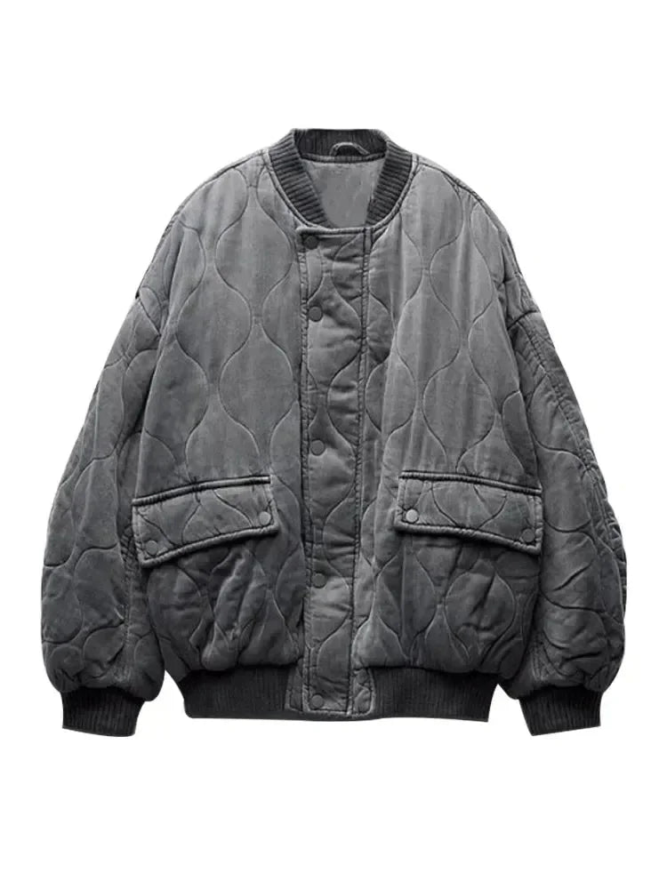 Women's quilted bomber jacket with snap closures, featuring a soft fabric, ribbed cuffs, and a stylish cropped design.